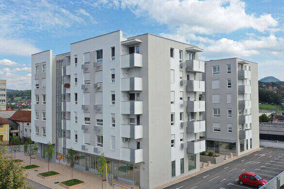 Zgrada sa uređenim drvoredom i parkingom